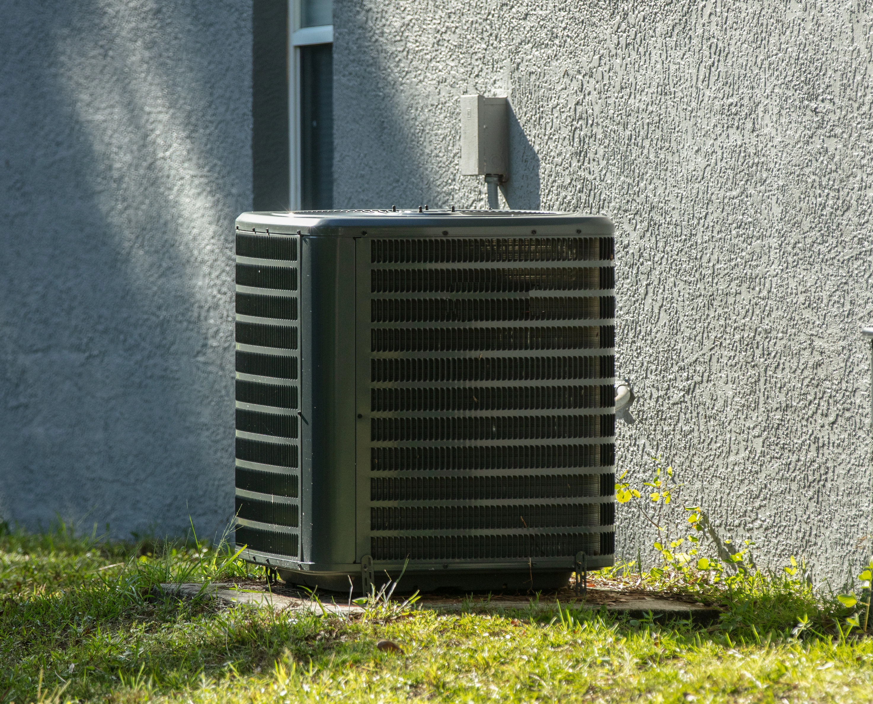 An outdoor HVAC unit in Tulsa receiving professional services from Air Dynamics.